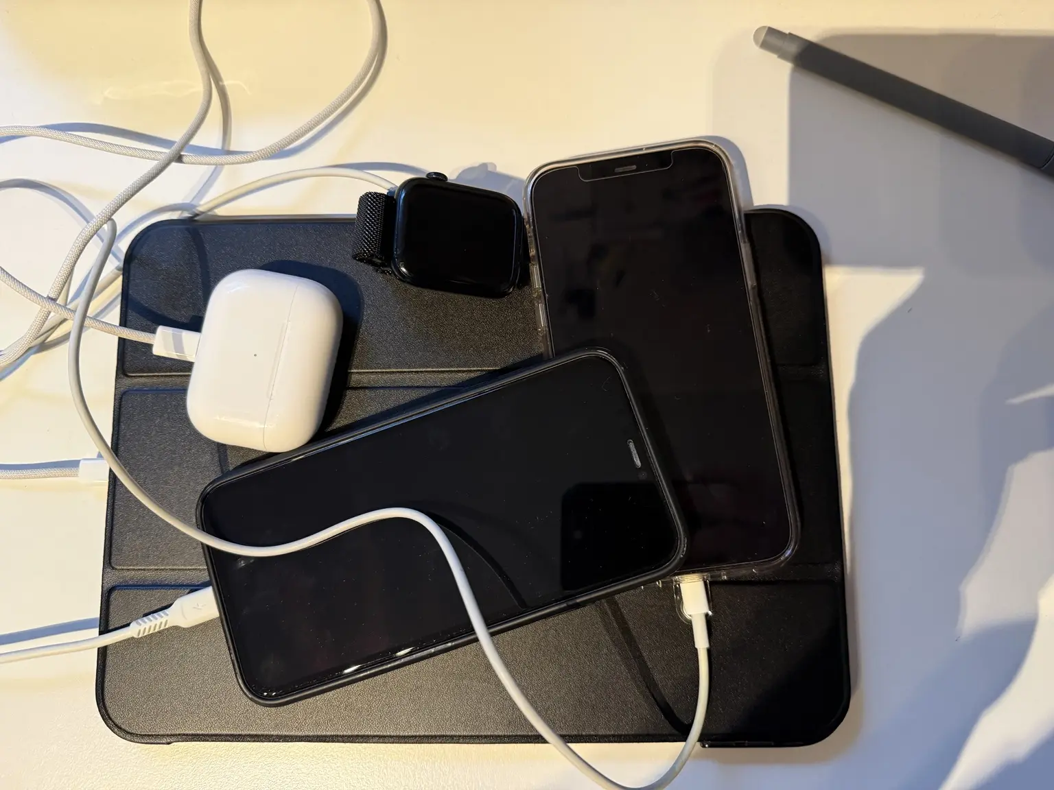 Smartphones, Apple Watch, AirPods und lose Ladekabel vor dem Bau der Ladestation
